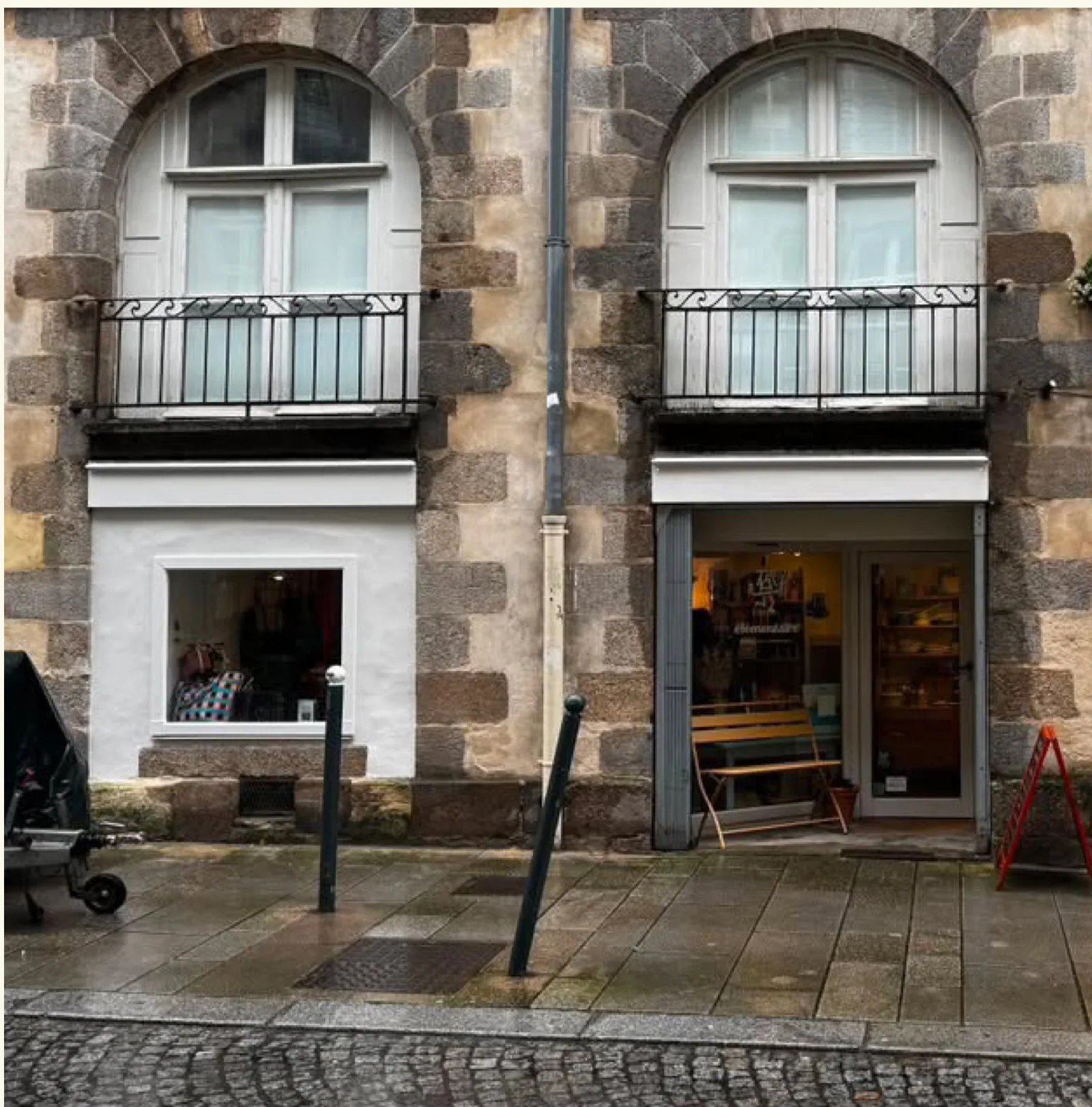 Façade de la boutique rue Bertrand à Rennes : deux fenêtres cintrées en pierre avec garde-corps en fer forgé au-dessus de la vitrine.